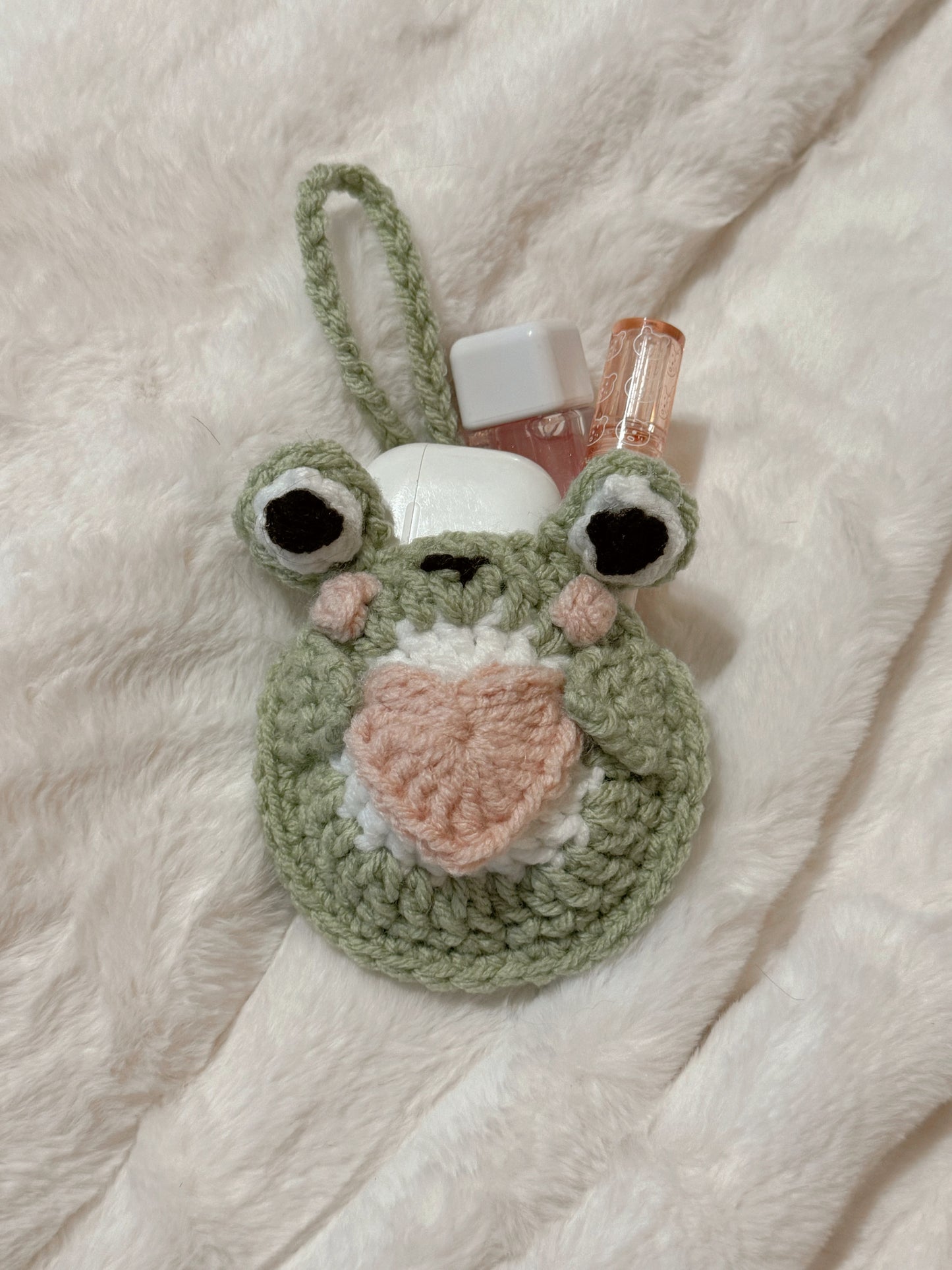 frog holding a heart pouch